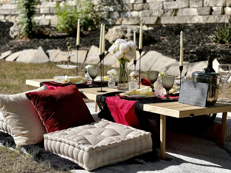 Styled outdoor hospitality setting with flowers, candles and glassware